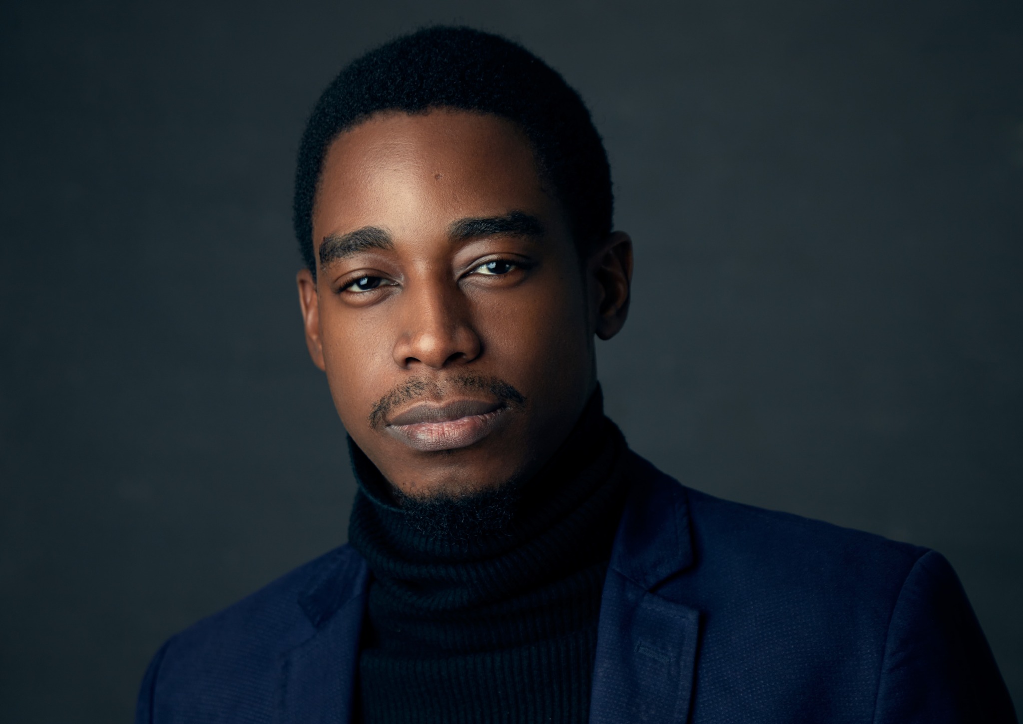 Portrait of Atta wearing a navy jacket and dark rollneck